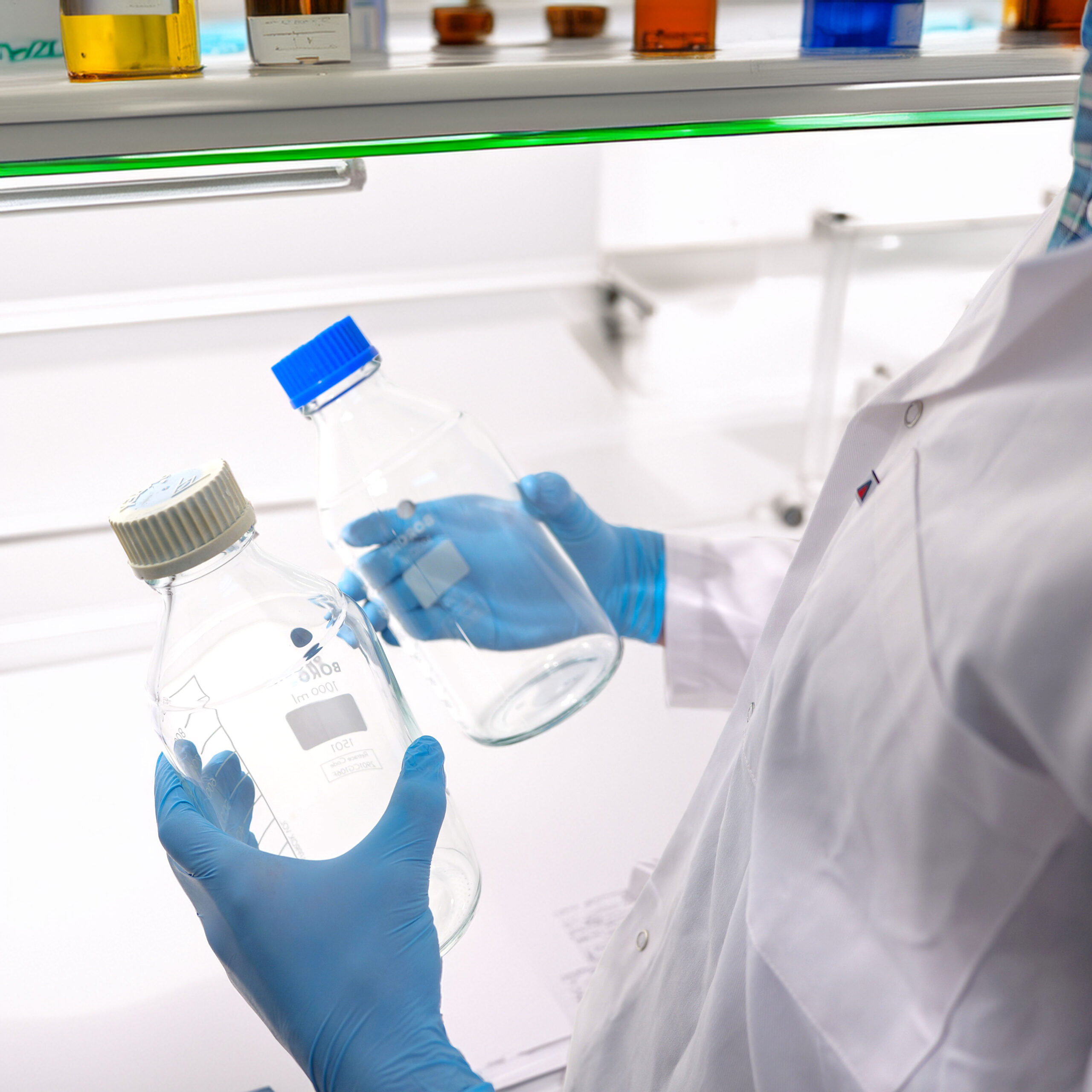 Reagent bottles showing two GL45 cap colours; one cap has faded to pale grey/white after lab use
